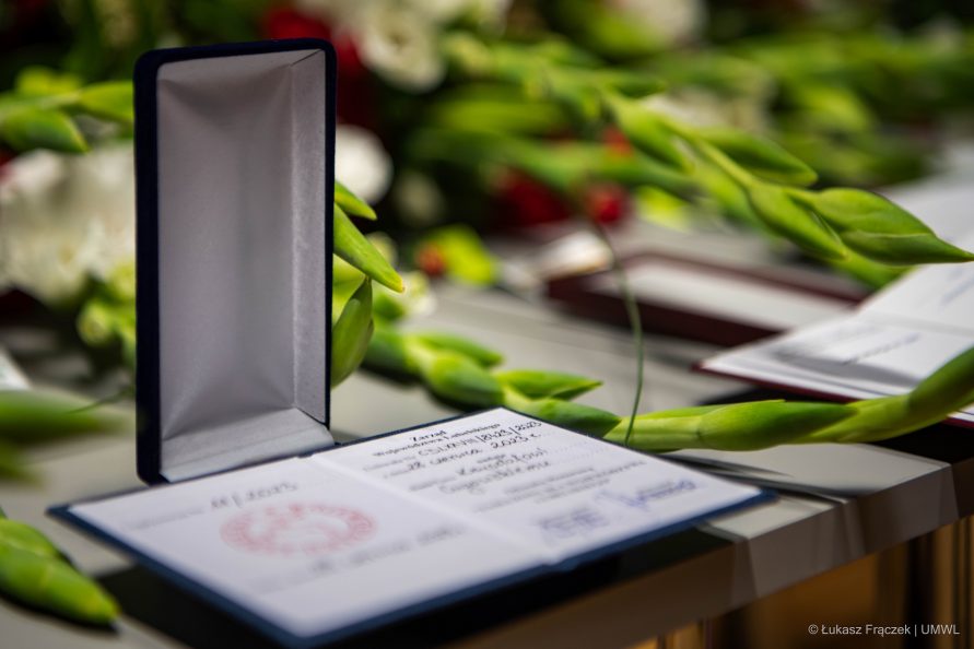 Podziękowanie w formie małej książeczki, oprawionej w skóę, leży na stole wśród kwiatów