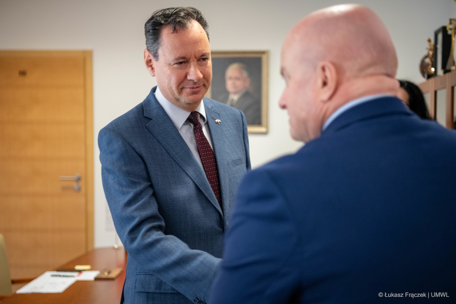 Stojący plecami do fotografa Marszałek Jarosław Stawiarski wita przybyłego ambasadora Izraela
