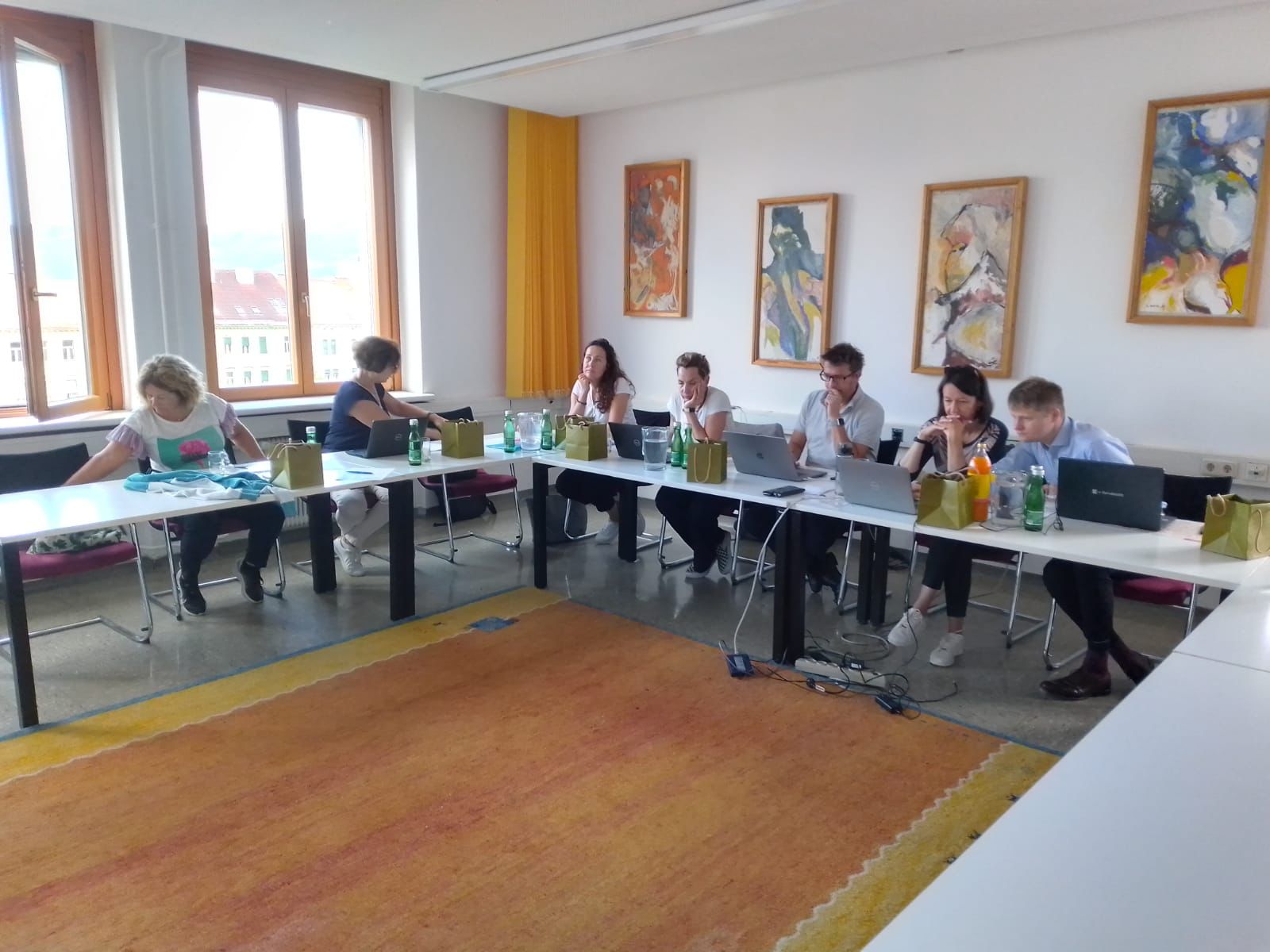 widok na osoby siedzące przy biurkach i słuchające wykladu