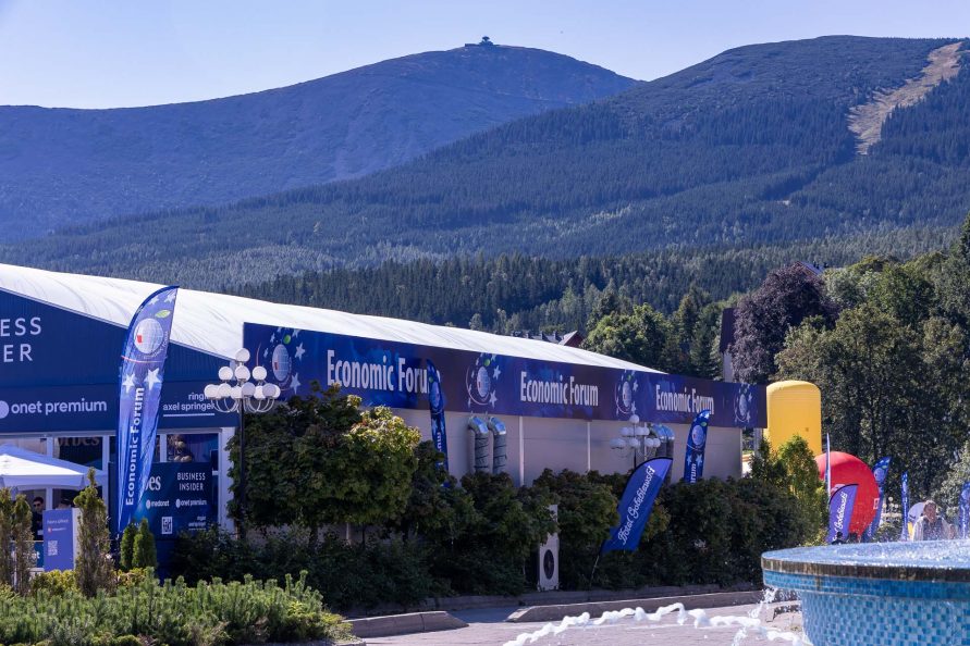 Na pierwszym planie widok na ustawiony duży namiot a w tle wysokie góry