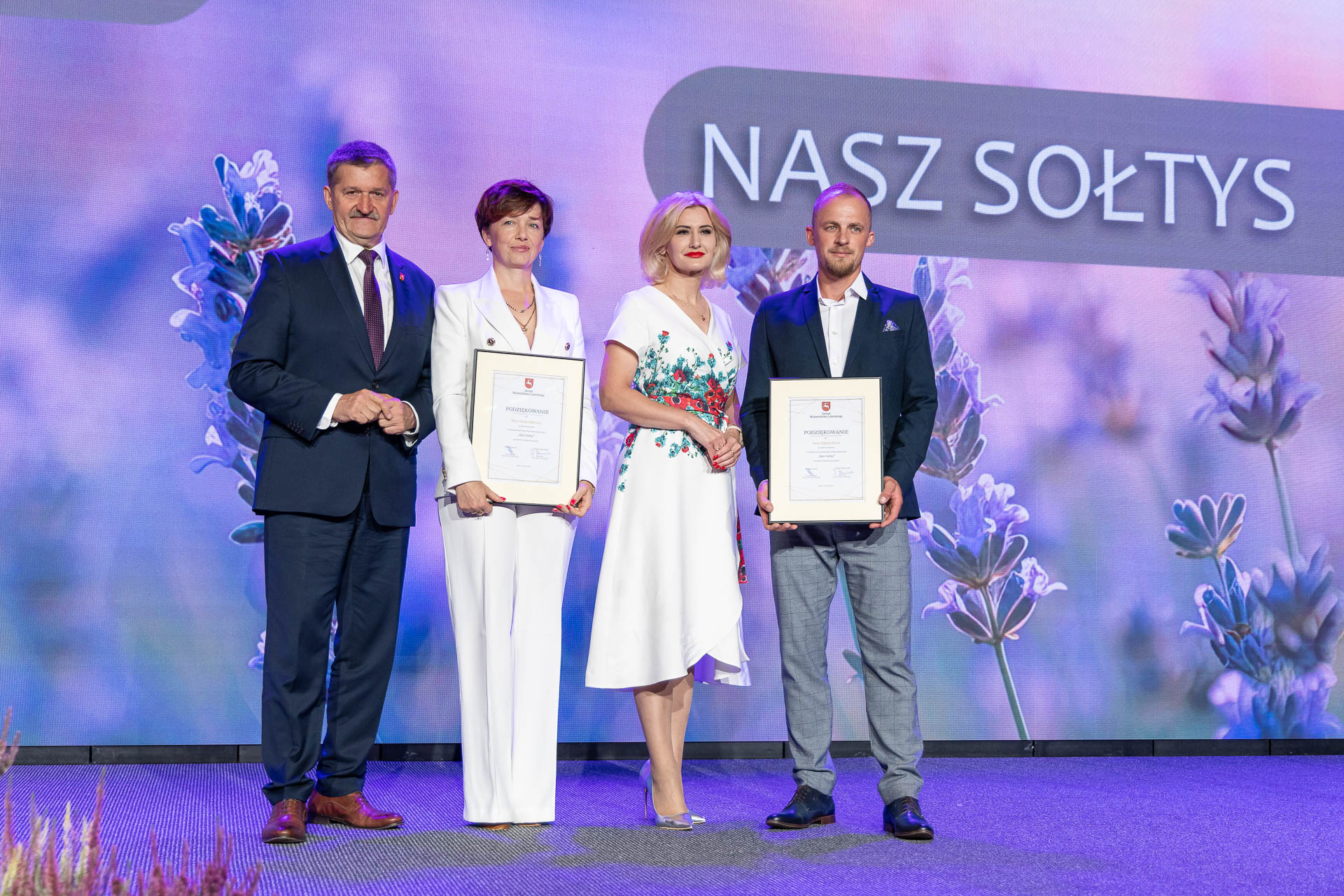 Zdzisław Szwed i Ewa Szałachwiej stoją wspólnie na scenie z laureatami podziękowań