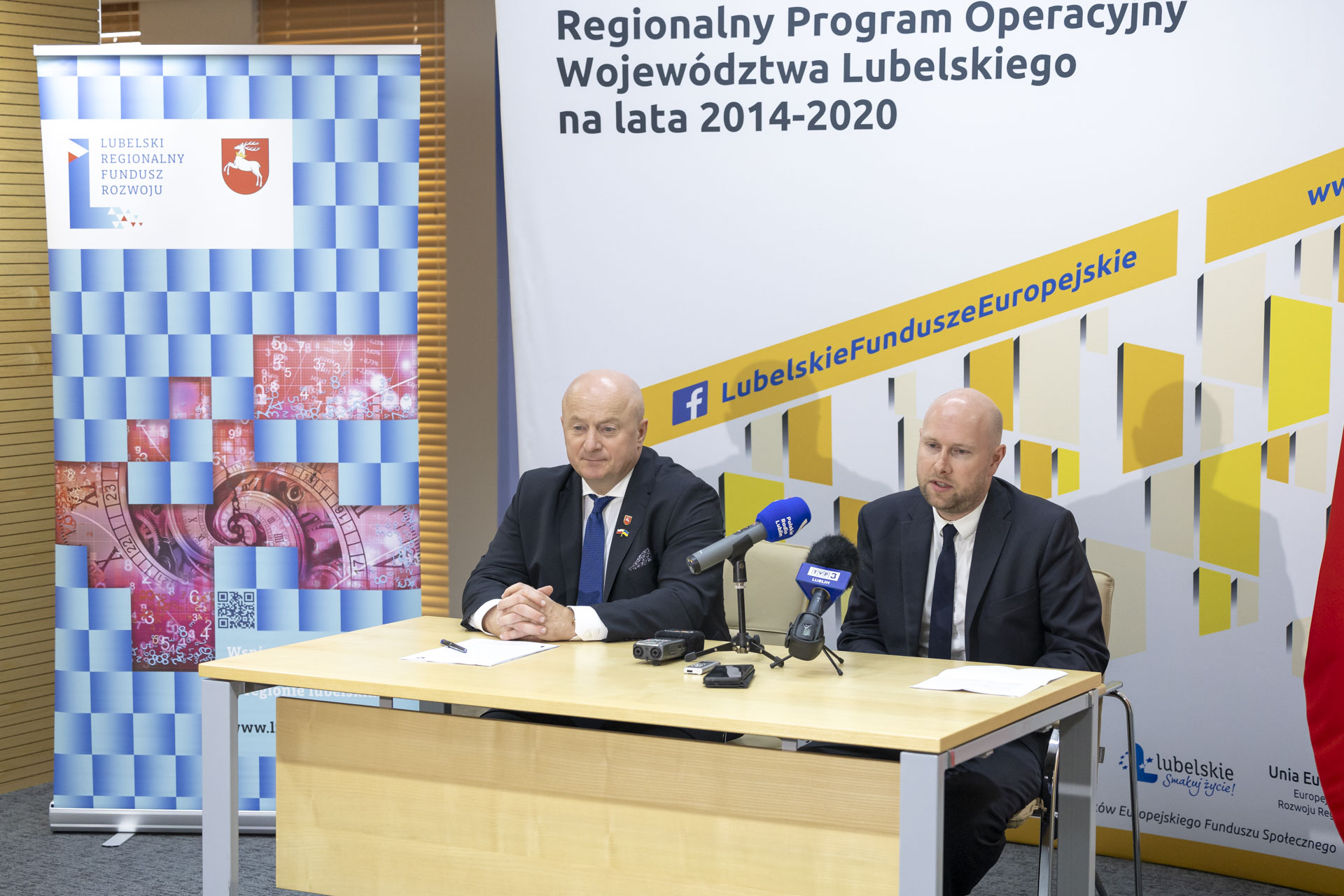 Jarosław Stawiarski i prezes LRFR siedzą wspólnie przy stoliku podczas konferencji prasowej, za nimi znajduje się ścianka Regionalnego Programu OPeracyjnego