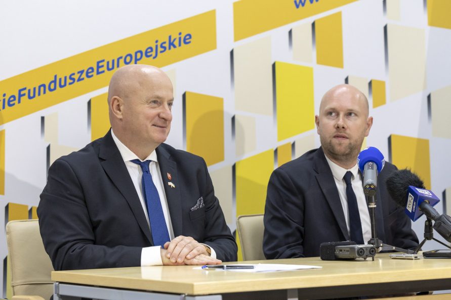 Jarosław Stawiarski w towarzystwie prezesa LRFR siedzą przy stole w trakcie konferencji prasowej