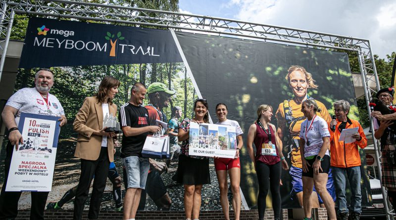 Laureaci biegu PolishRun stoją na scenie i pozują do zdjęcia