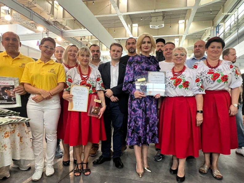 grupa osób trzymająca nagrody i wyróżnienia