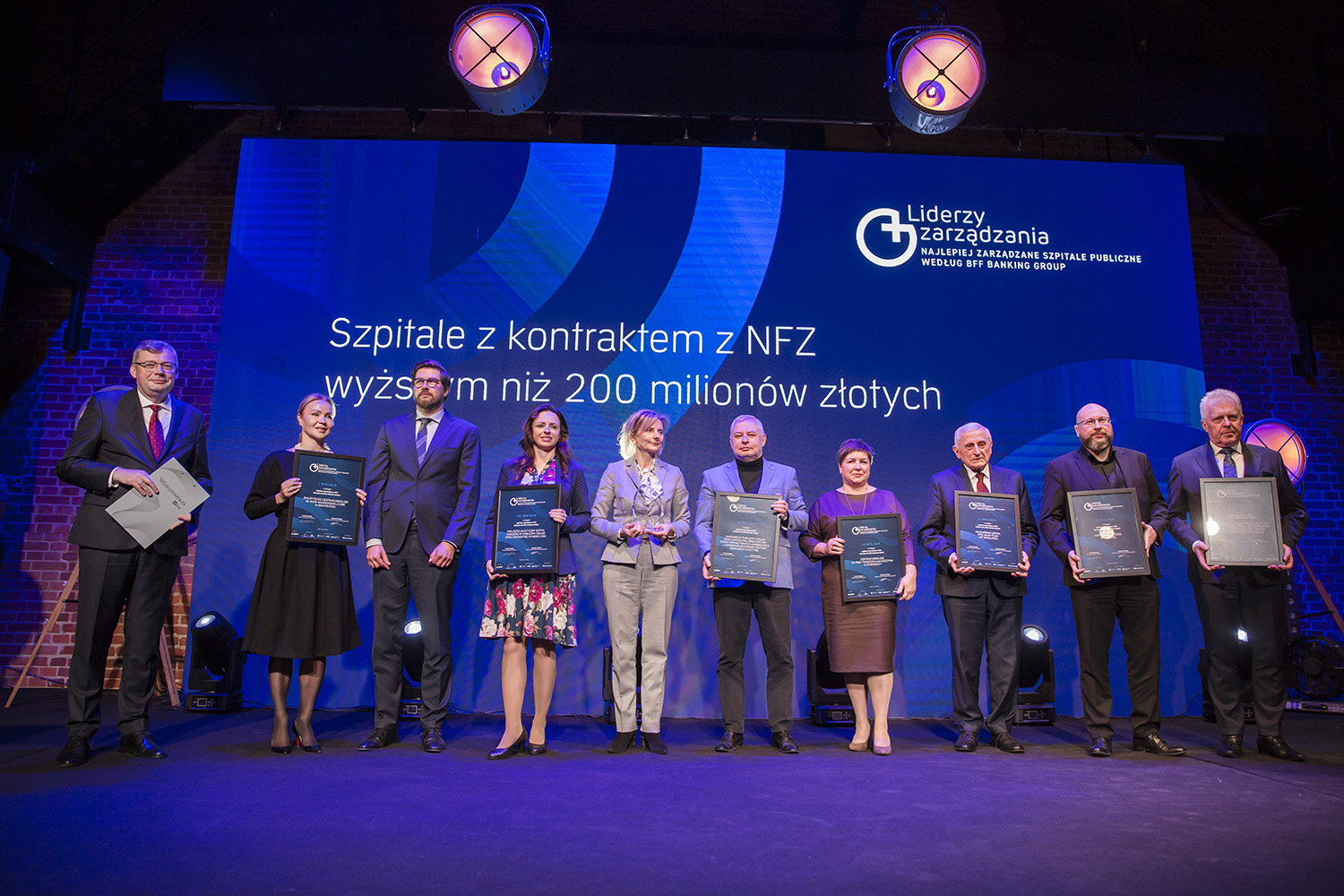 Przedstawiciele szpitali samorządowych województwa lubelskiego pozują na scenie wspólnie do zdjęcia