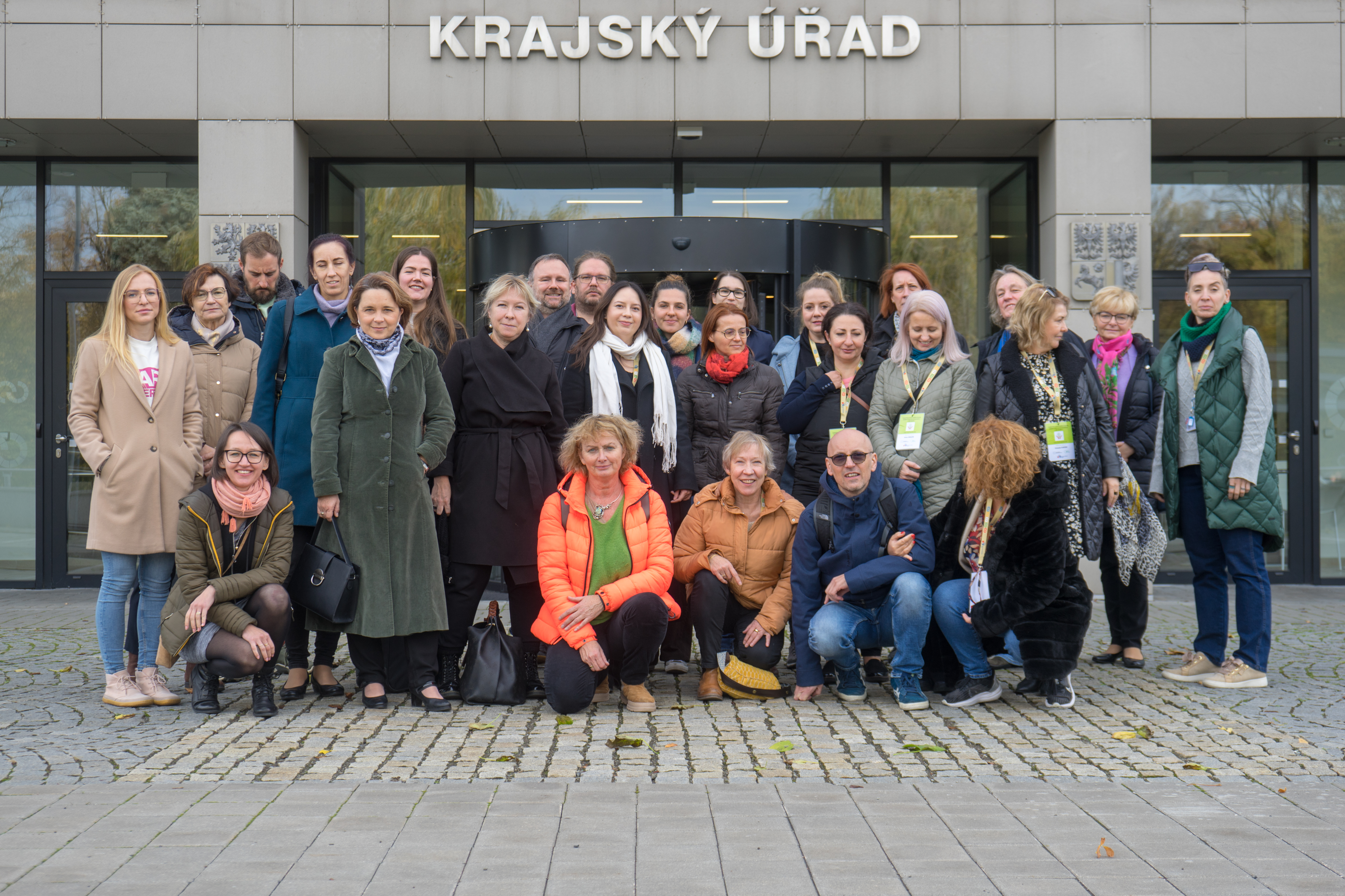 Zdjęcie grupowe na którym pozuje około dwudziestu osób ustawionych w trzech rzędach, w grupie znajdują się zarówno kobiety jak i mężczyźni w średnim wieku