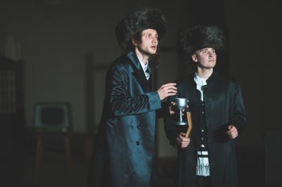 dwóch mężczyzn w ciemnych surdutach i w futrzanych czapkach