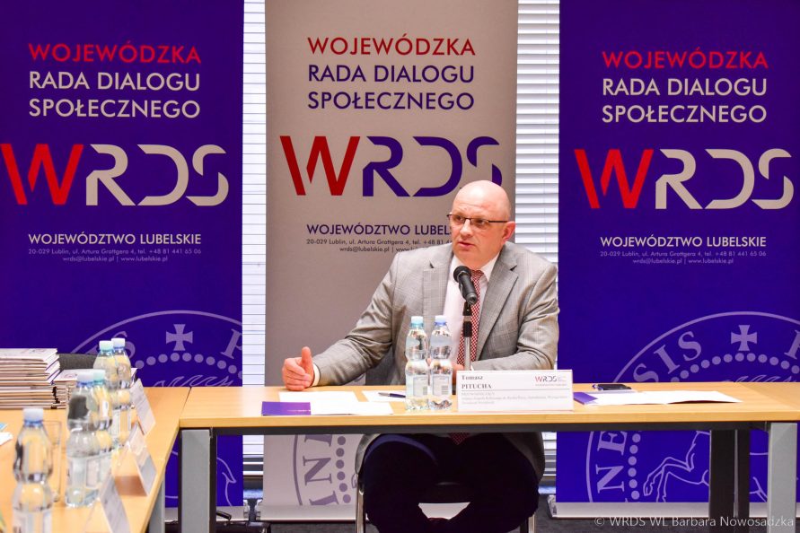 Przewodniczący przemawia do zebranych na posiedzeniu osób