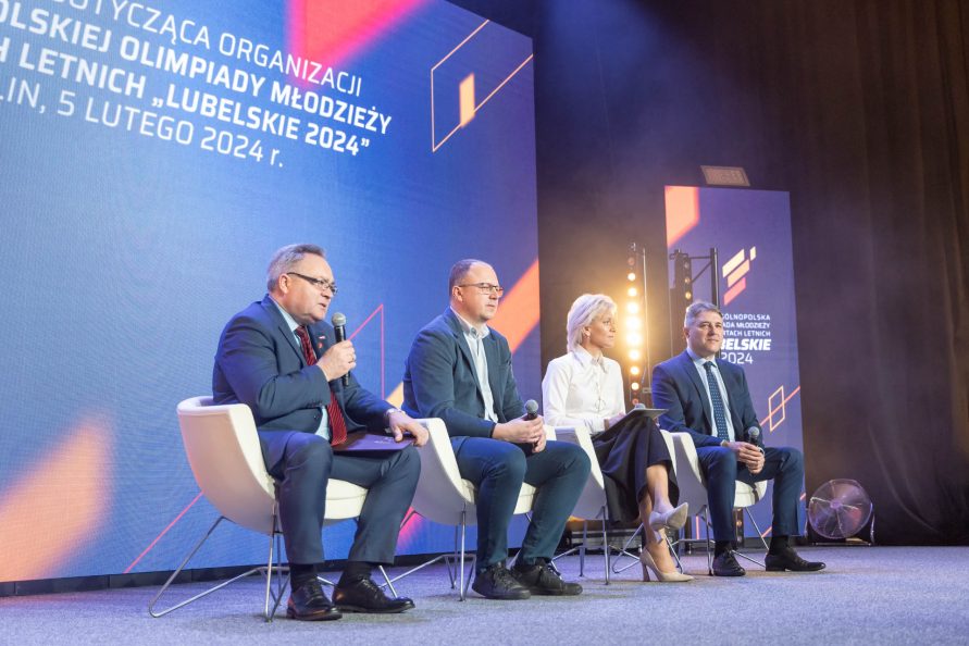 Cztery osoby siedza na scenie na fotelach i odpowiadają na pytania podczas trwającej konferencji prasowej