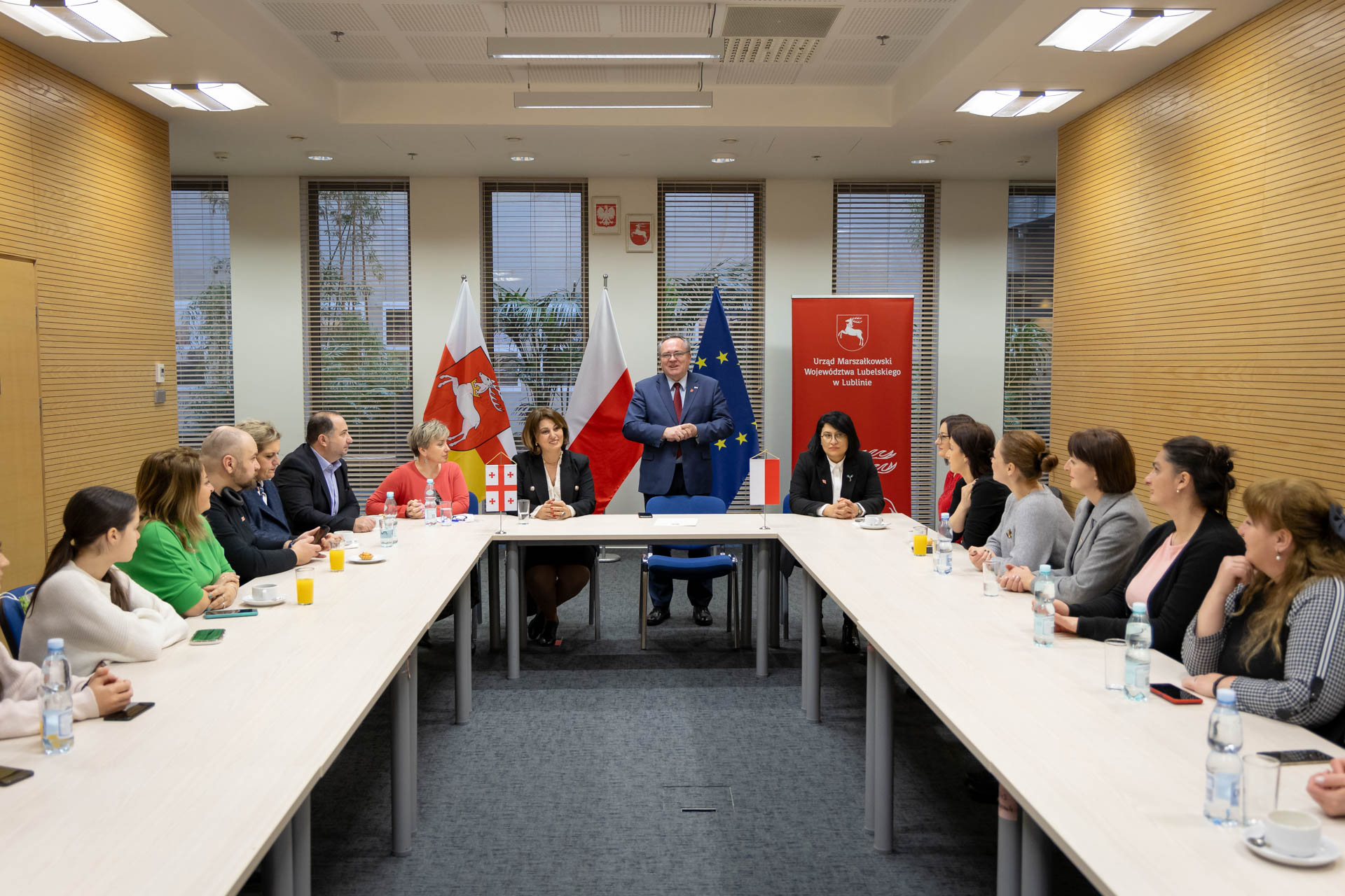 Goście z Gurii siedzący przy stole podczas wystąpienia Wicemarszałka Zbigniewa Wojciechowskiego