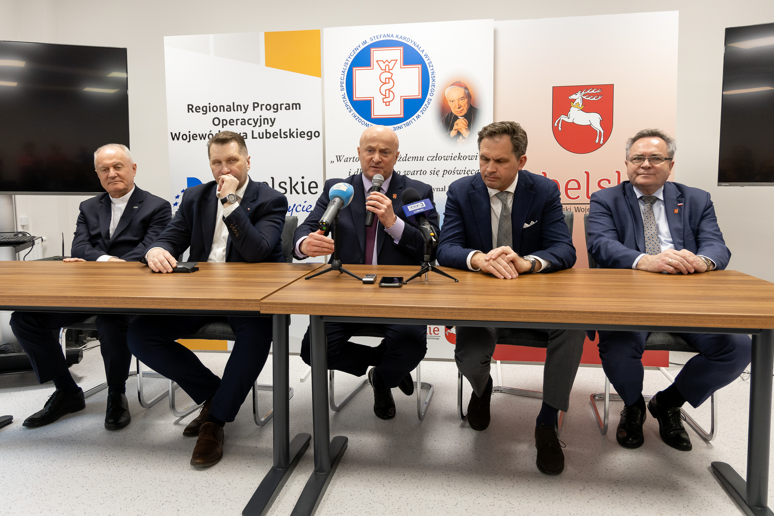 Pięciu mężczyzn, prelegentów konferencji medycznej, pośrodku siedzi marszałek Jarosław Stawiarski