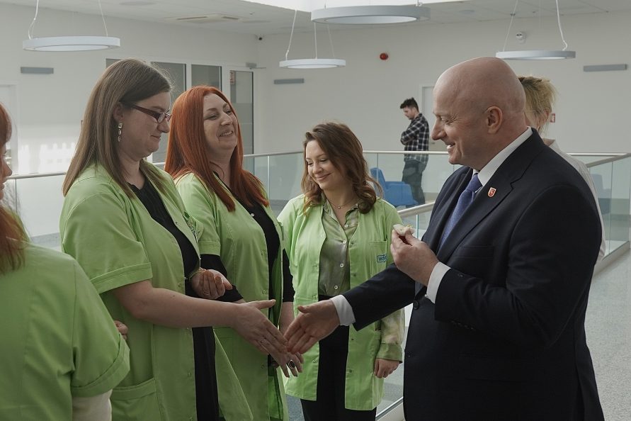 Marszałek Jarosław Stawiarski podaje rękę kobiecie pracującej w przychodni. Obok stoją dwie kobiety.