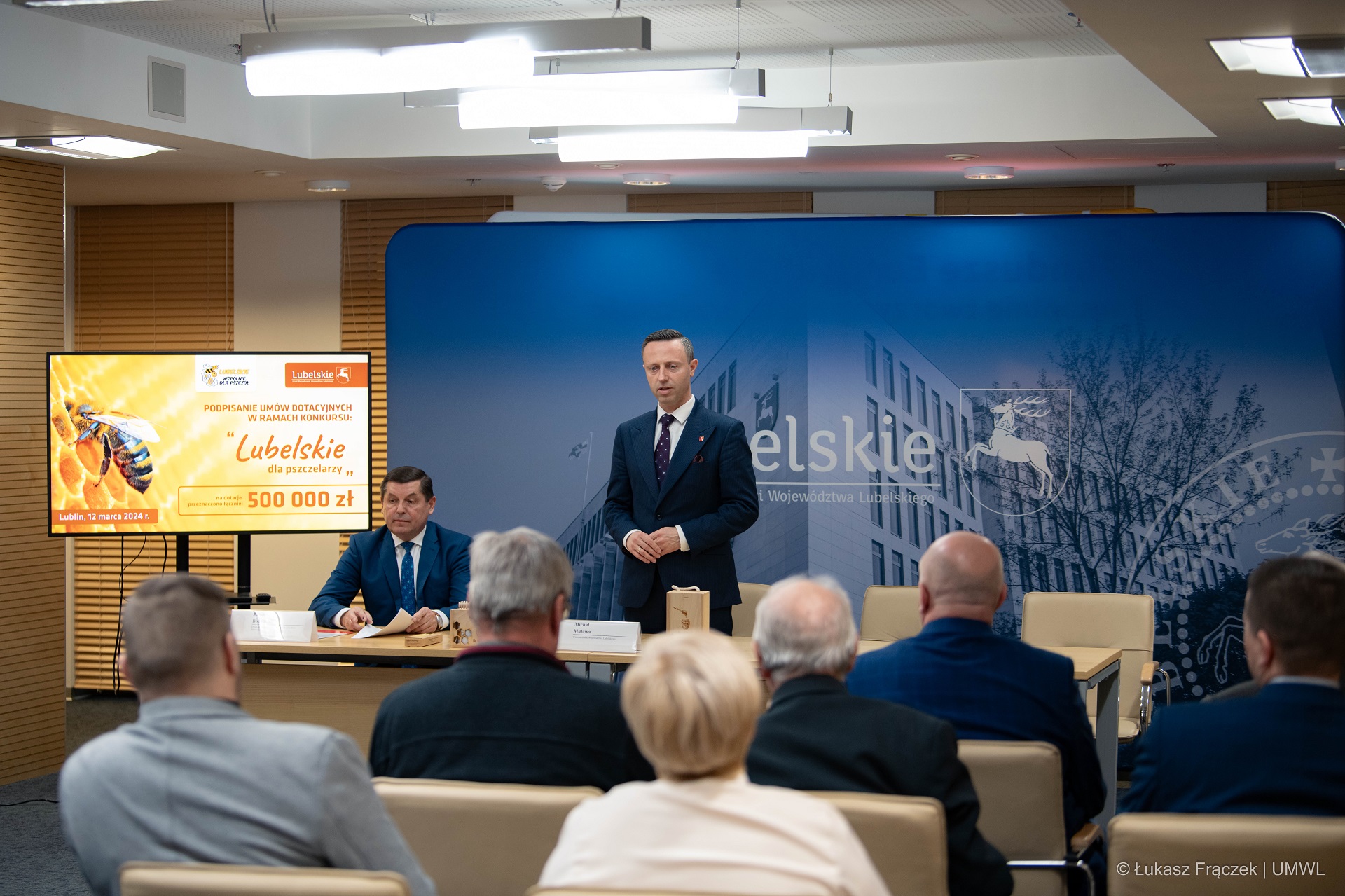 Wicemarszałek Michał Mulawa stoi w sali konferencyjnej i przemawia do zebranych osób