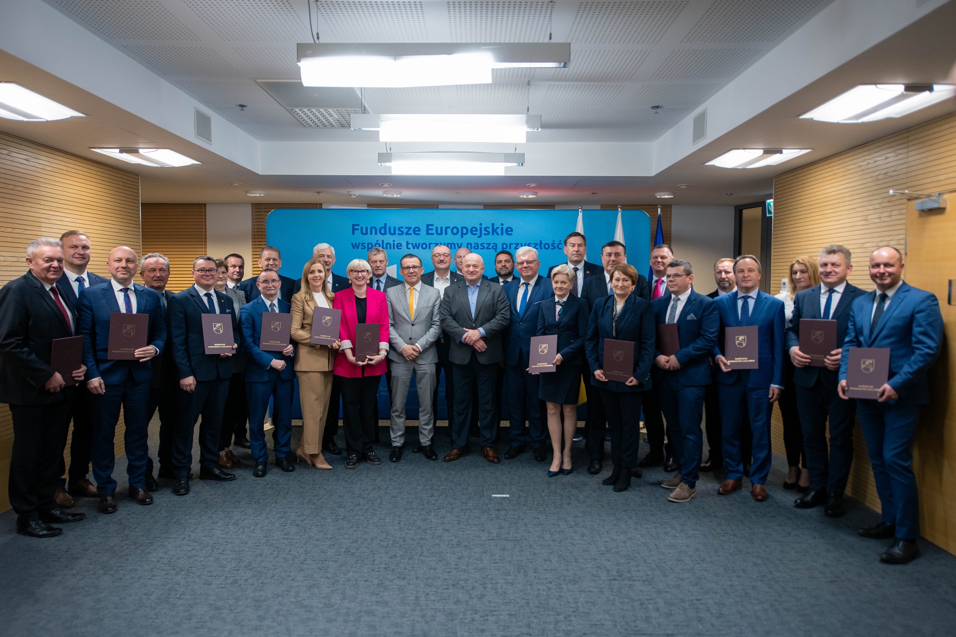 Wspólnie zdjęcie wszystkich beneficjentów dofinansowań na kształcenie. Na zdjęciu znajduje się około dwudziestu osób, wszyscy stoją w sali konferencyjnej w towarzystwie marszałka województwa lubelskiego.
