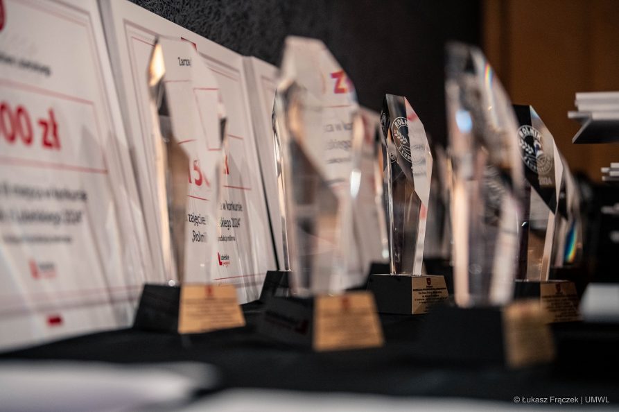 Szklane statuetki oraz dyplomy dla laureatów stoją ustawione na stole