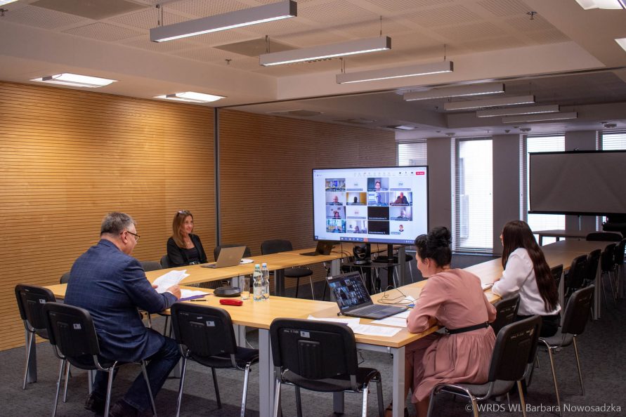 Uczestnicy zdalnego posiedzenie Plenarnego 06.05.2024r. - na sali siedzą cztery osoby przy ekranie monitora
