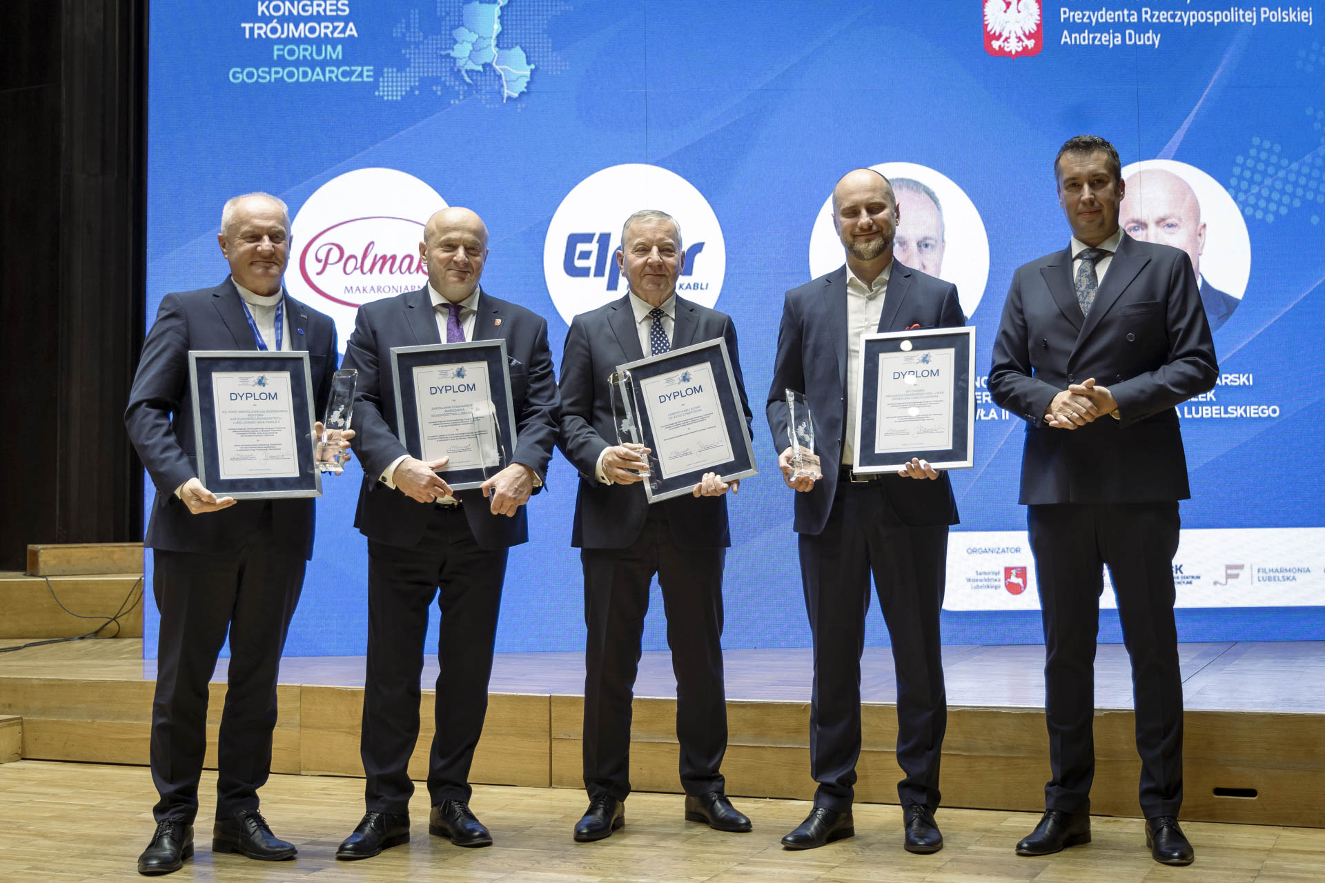 Laureaci nagród honoworych kongresu Trójmorza pozują wspólnie do zdjęcia. Jest to czterech mężczyzn w towarzystwie Członka Zarządu Marcina Szewczaka