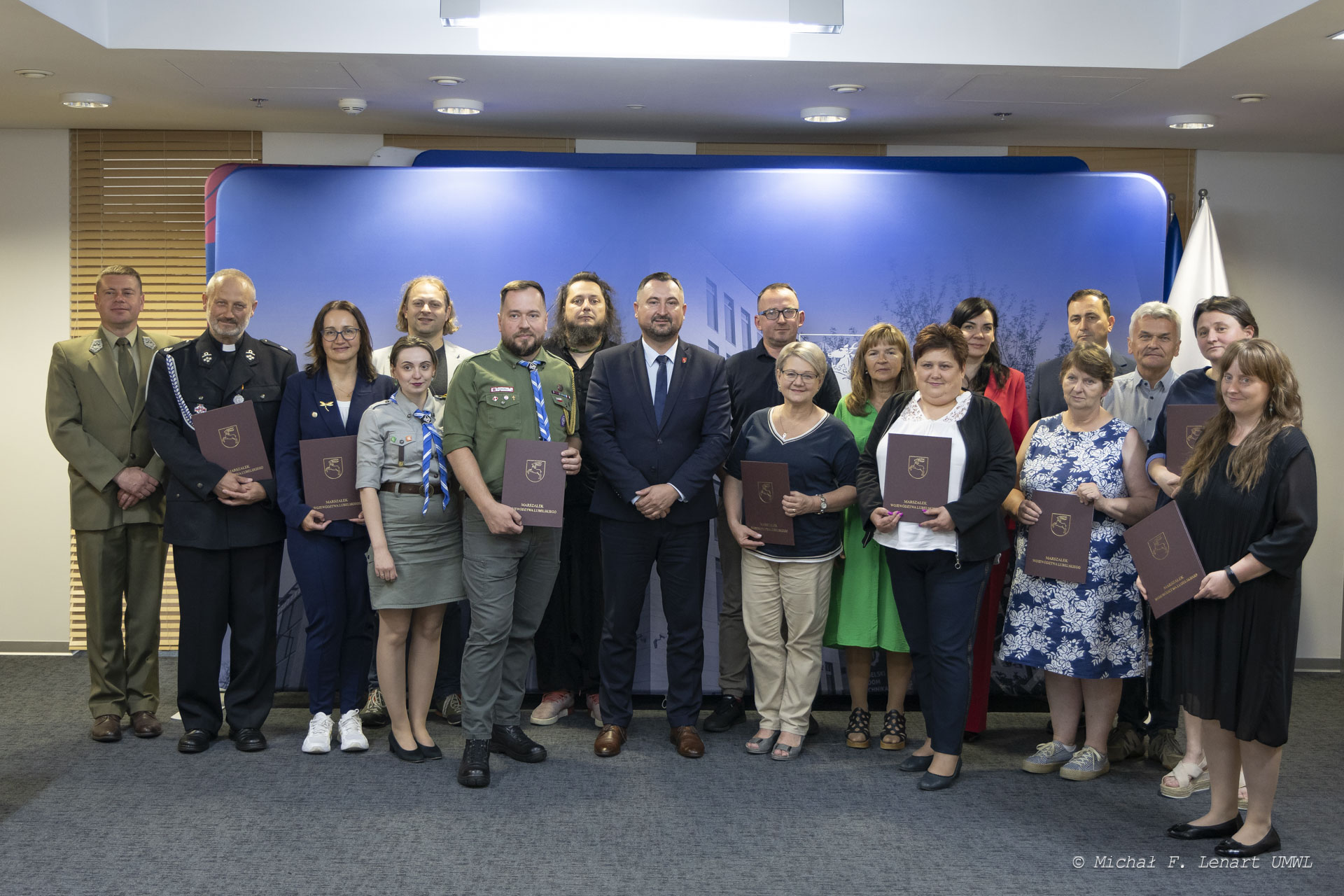 Na zdjęciu znajduje się kilkanaście osób sa to beneficjeni programu, wszyscy pozują do zdjęcia wspólnie zwicemarszałmkiem Markiem Wojciechowskim