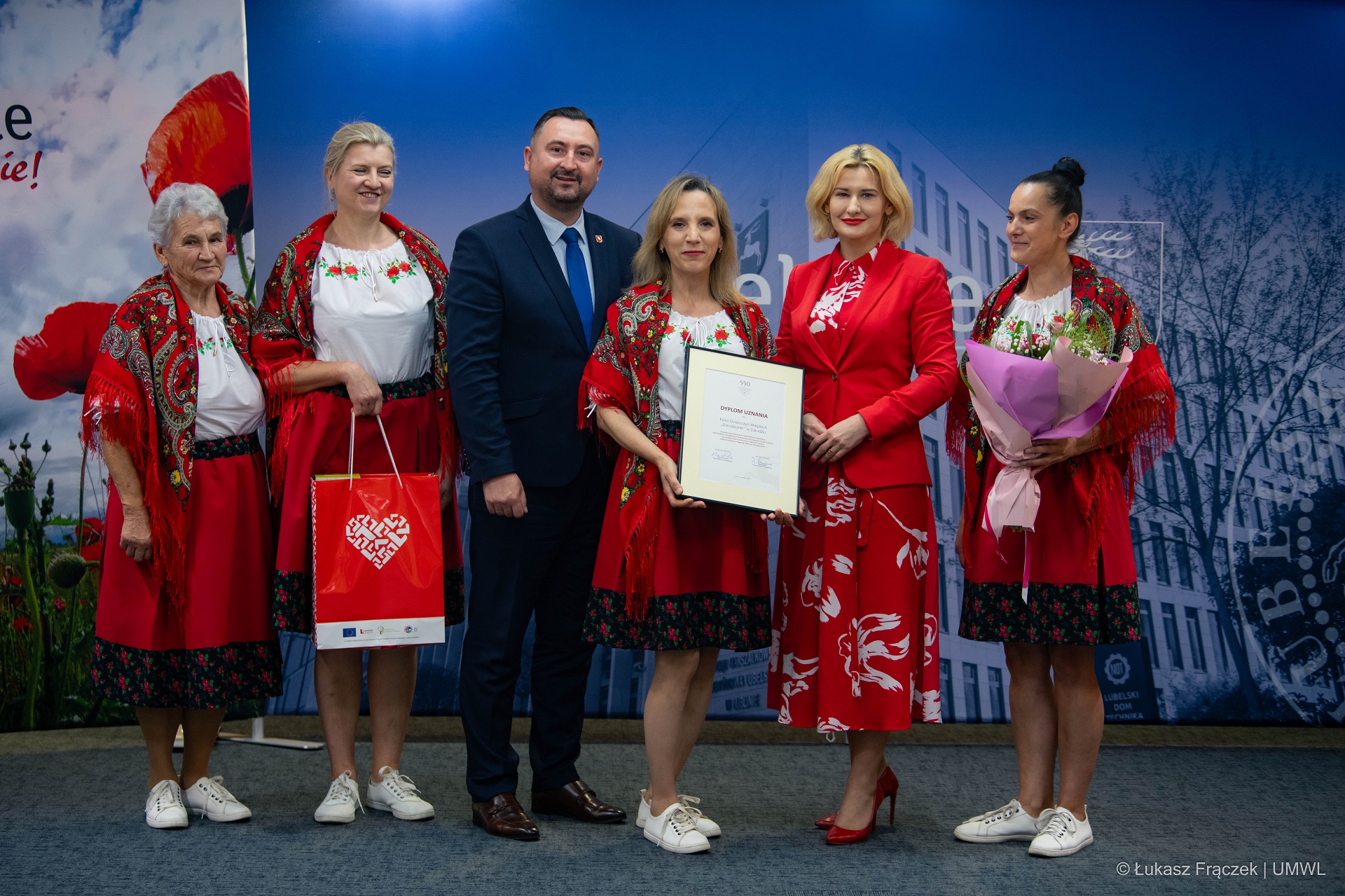 Wicemarszałek Marek Wojciechowski w towarzystwie kobiet ubranych w stroje ludowe