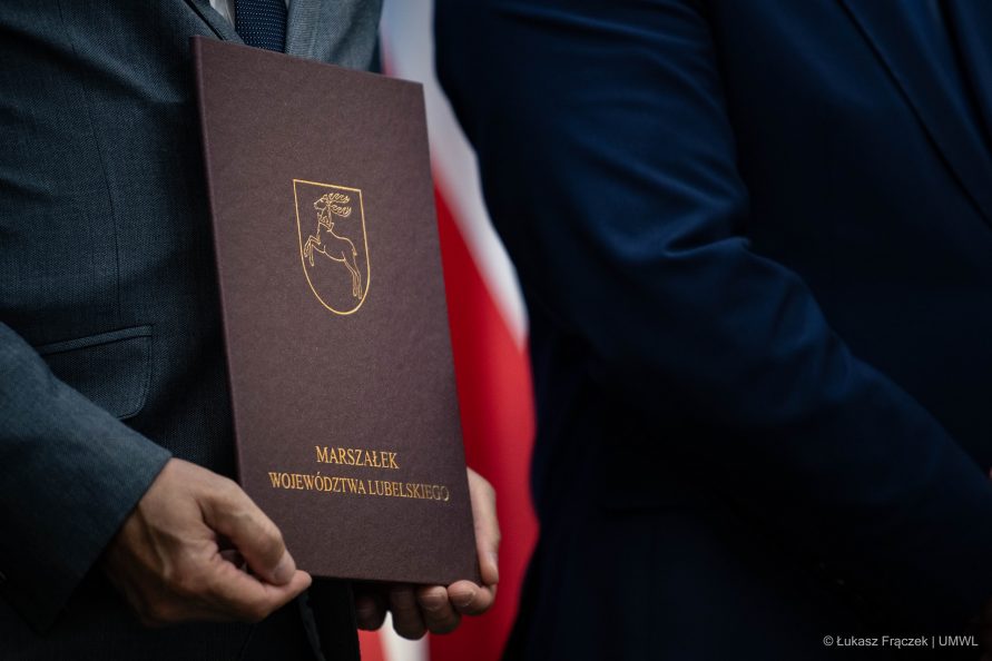 Teczka z napisem marszałek województwa lubelskiego, trzymana w rękach przez mężczyznę