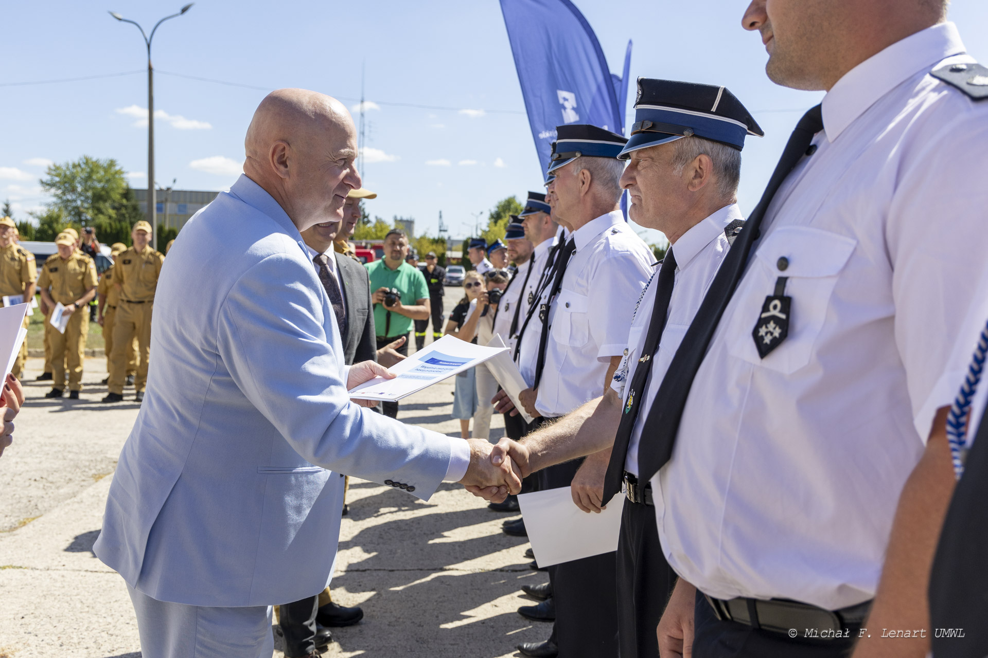 Marszałek Jarosław Stawiarski podaje dłoń strażakowi