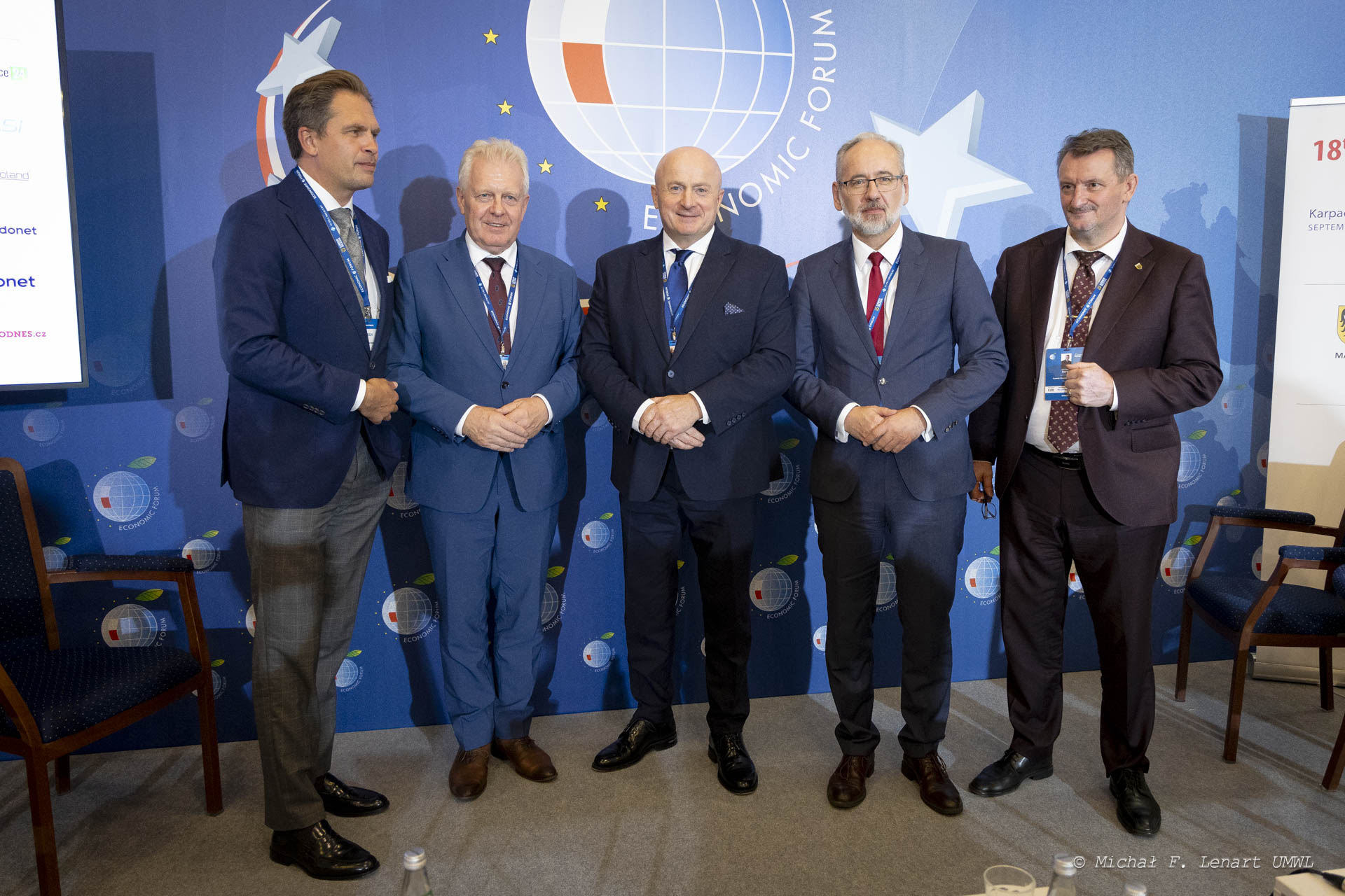 Pięciu mężczyzn stoi na ściance forum ekonomicznego w Karpaczu, wśród nich stoi marszałek Jarosław Stawiarski