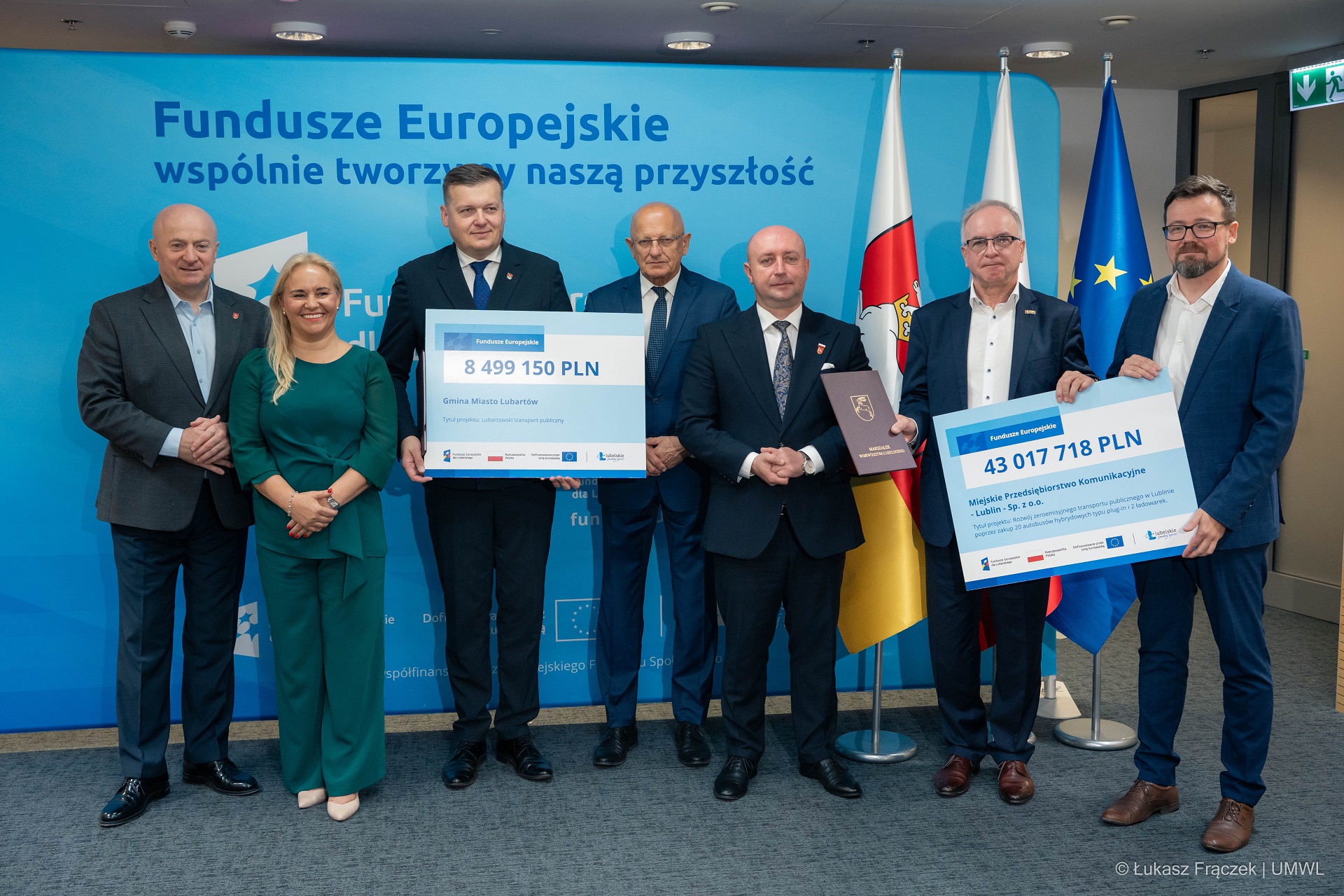 Marszałek Jarosław Stawiarski i wicemarszałek Piotr Breś pozują do zdjęcia w sali konferencyjnej w towarzystwie beneficjentów programu UE