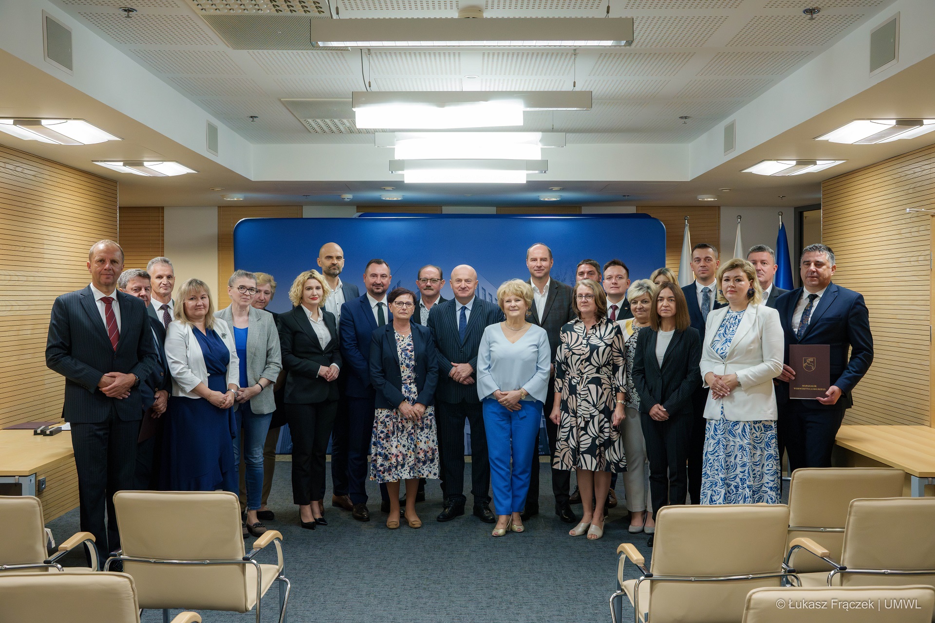 Grupowe zdjęcie beneficjentów którzy otrzymali dotacje w towarzystwie marszałka Jarosława Stawiarskiego i wicemarszałka Marka Wojciechowskiego, razem na zdjęciu znajduje się około dwudziestu osób