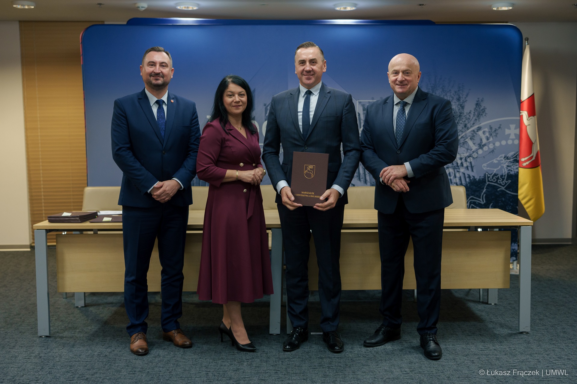 Jarosław Stawiarski marszałek i wicemarszałek Marek Wojciechowski pozują do zdjęcia z beneficjentami