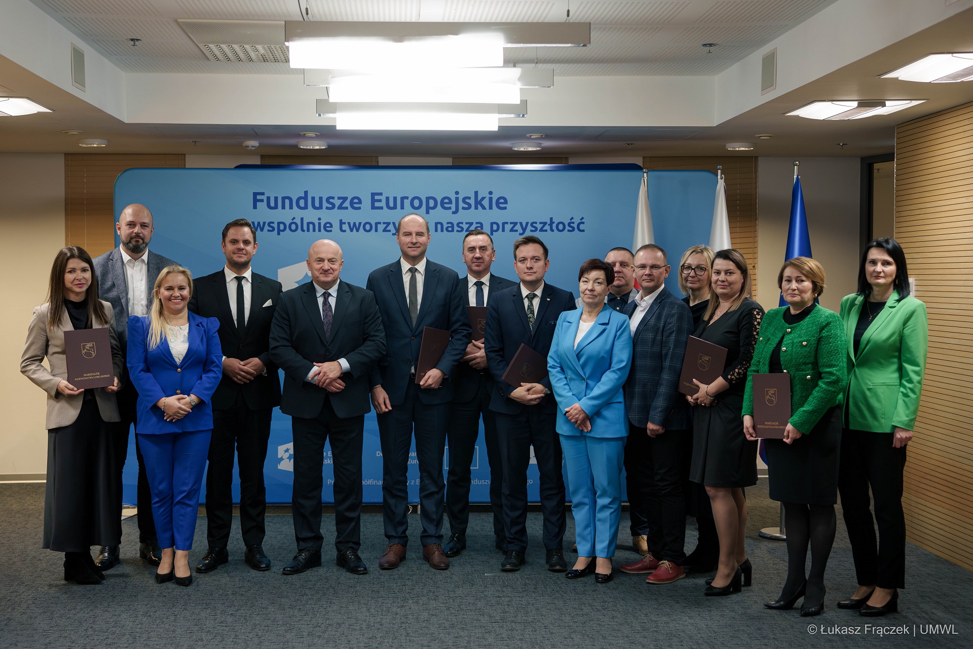 Około dwunastu osób pozuje wspólnie do zdjęcia w z marszałkiem województwa Lubelskiego, sa to beneficjenci programu