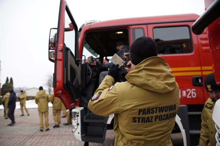 Strażak robi zdjęcie otrzymanego wozu strażackiego