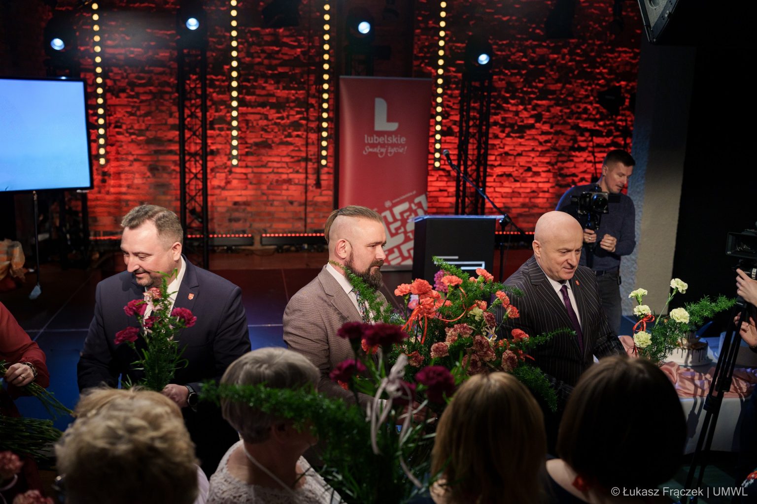 Marszałek Jarosław Stawiarski i wicemarszałek Marek Wojciechowski rozdają kwiaty z okazji dnia kobiet