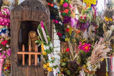 kolorowe palmy wielkanocne oraz drewniana rzeźba chrystusa