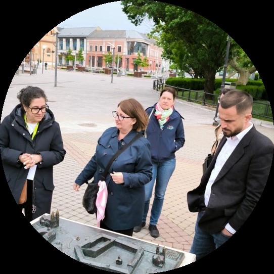 Uczestnicy spotkania oglądają miniaturę budynku historycznego.