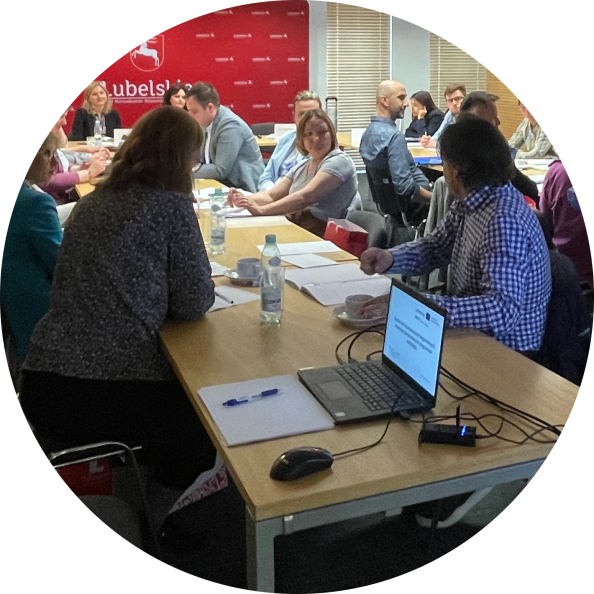 Grupa uczestników spotkania przy stole