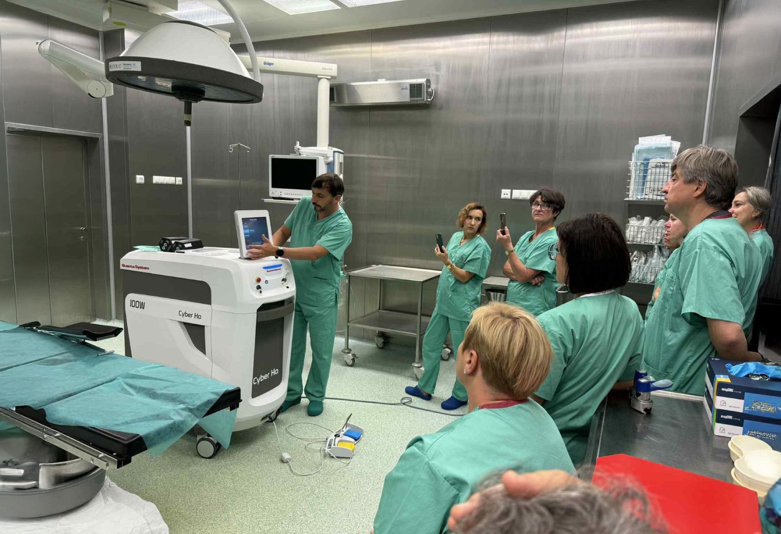 Grupa lekarzy w fartuchach na sali zabiegowej przy sprzecie medycznym