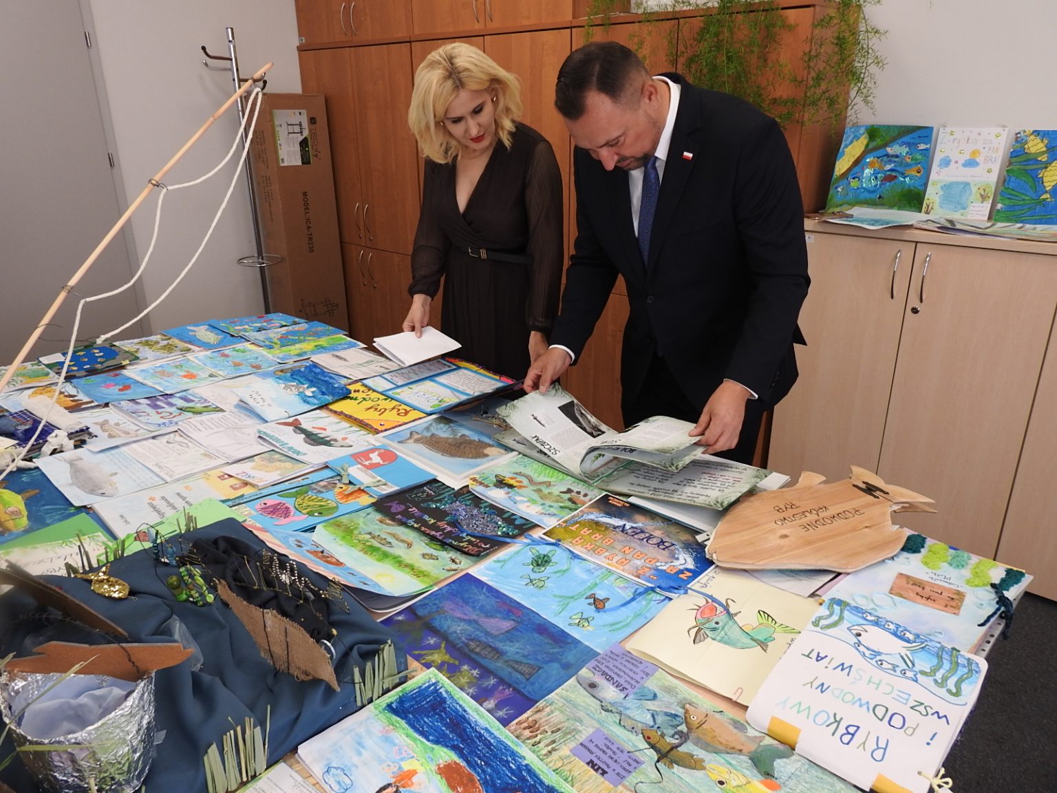 Wicemarszałek Marek Wojciechowski i Dyrektor Departamentu Rolnictwa i Rozwoju Obszarów Wiejskich Ewa Szałachwiej dokonujący oceny prac w konkursach "Złap Rybkę 2025" i "Z Rybką za Pan Brat 2025"