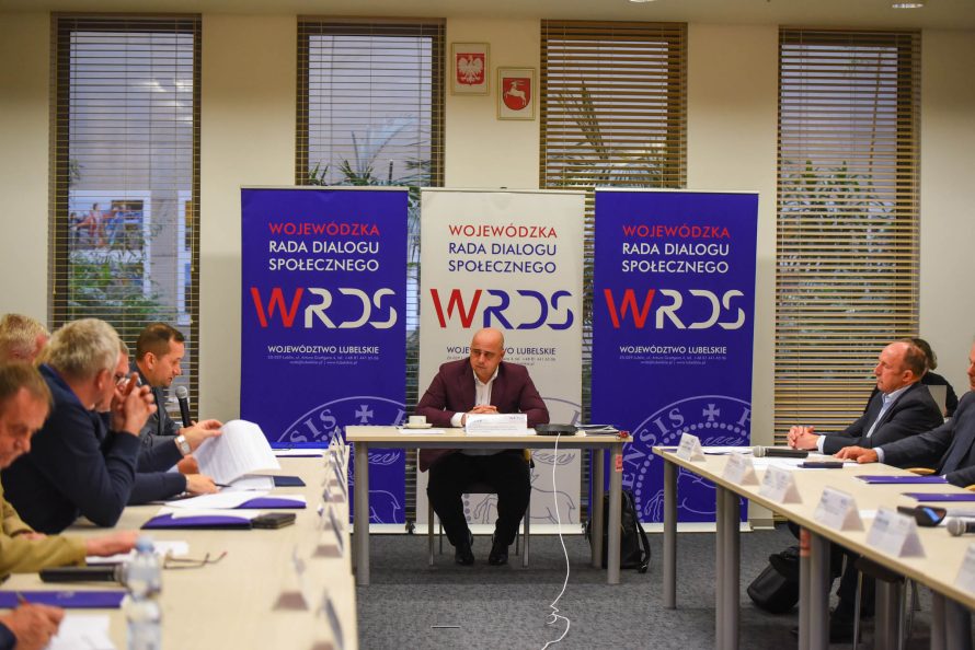 Przewodniczący Dariusz Miller i członkowie SZR ds. Gospodarki, Innowacji i Rozwoju Przedsiębiorczości siedzą przy stołach ustawionych w kształcie litery U w tracie obrad