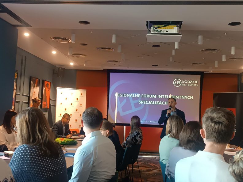 zdjęcie przedstawia grupę ludzi podczas prezentacji na spotkaniu Regionalnego Forum Inteligentnych specjalizacji