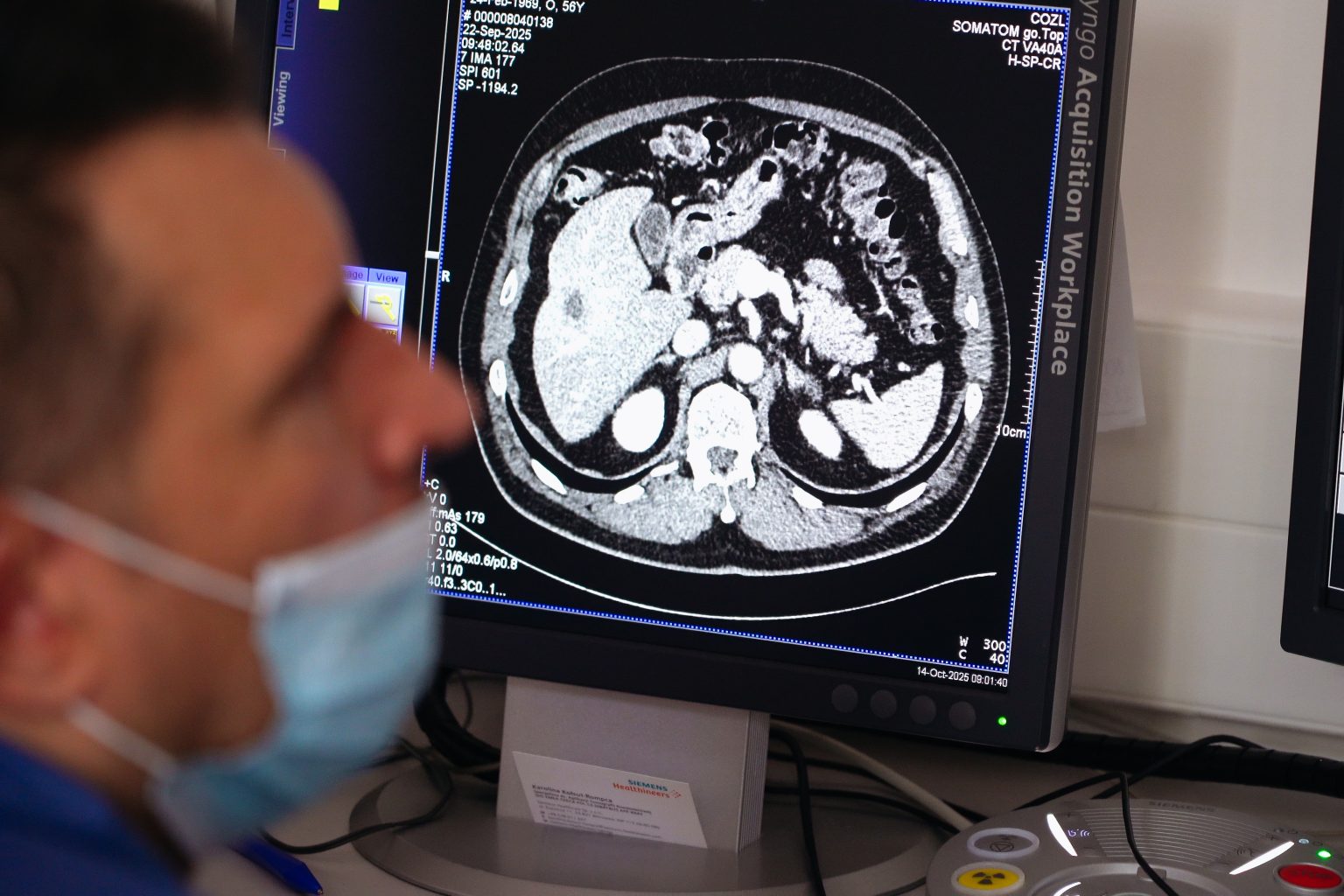 Lekarz podczas badania z wyświetlającym się obrazem narządów pacjenta na ekranie