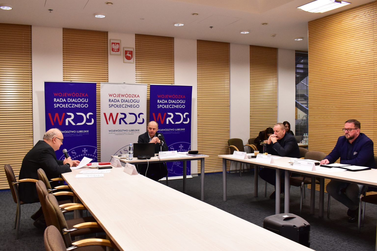 Czterech członków SZR siedzi przy stołach ustawionych w litere U: Przewodniczący Maciej Buczyński, Zbigniew Rymasz, Pan Maciej Nejkauf i Pan Robert Blicharski.