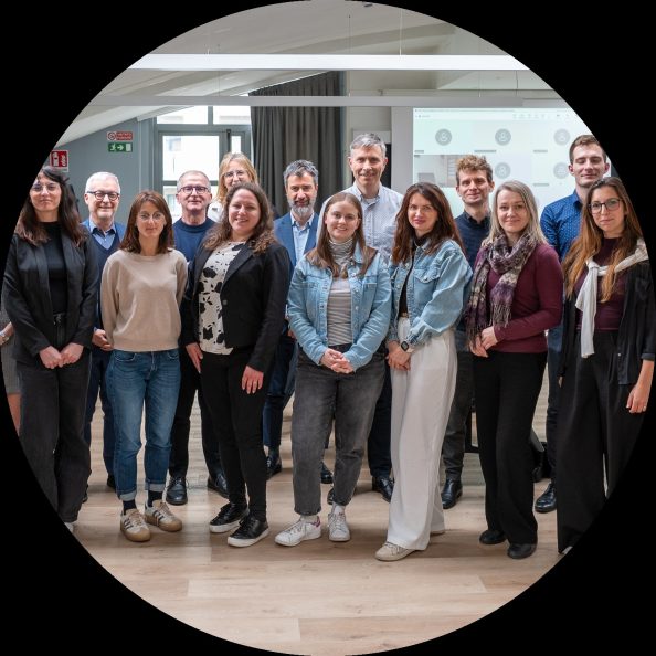 Grupa partnerów w ramach projektu ADAPTO pozuje stojąc obok siebie.