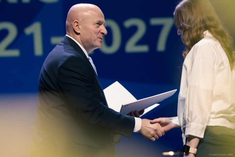 Marszałek Jarosław Stawiarski wręcza nagrode sytpednystce